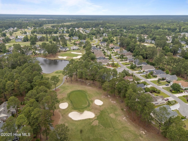view of property location with a golf course, nearby suburban area, and a large body of water