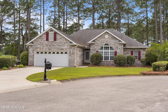 view of front of home featuring driveway, brick siding, a front yard, and a garage