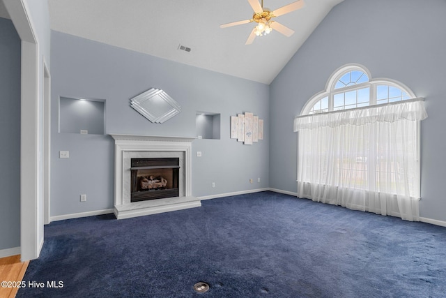 unfurnished living room with high vaulted ceiling, ceiling fan, carpet floors, a fireplace, and baseboards
