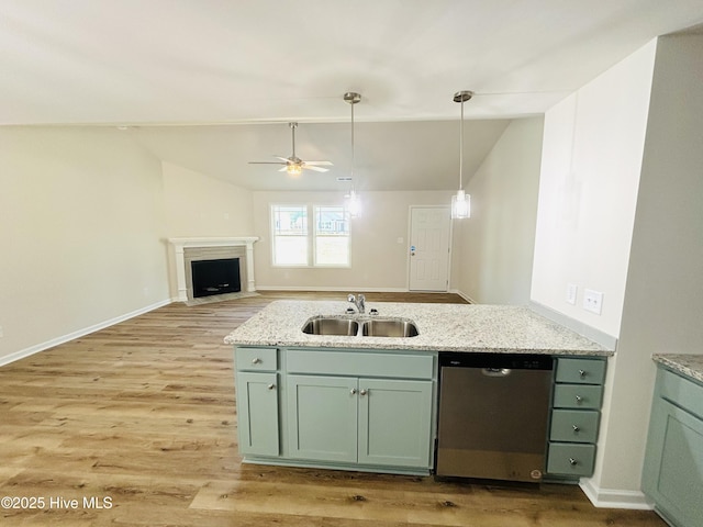 kitchen featuring a sink, dishwasher, lofted ceiling, green cabinets, and light wood-style floors