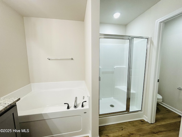 full bathroom featuring a stall shower, wood finished floors, a bath, and toilet