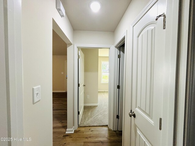 corridor featuring wood finished floors and baseboards