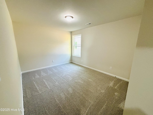 unfurnished room featuring carpet and baseboards