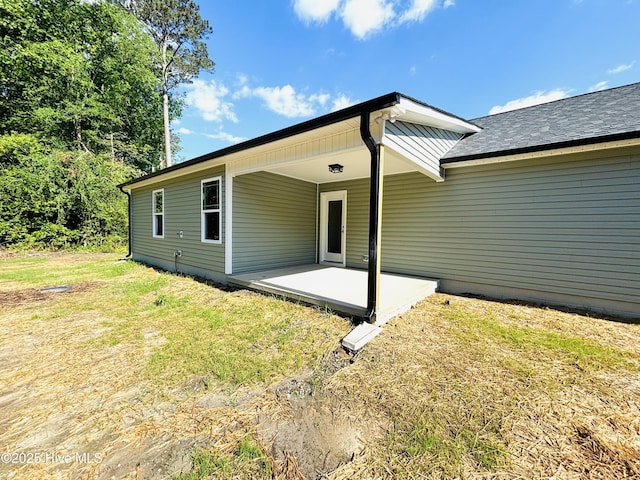 rear view of house featuring a patio area and a lawn