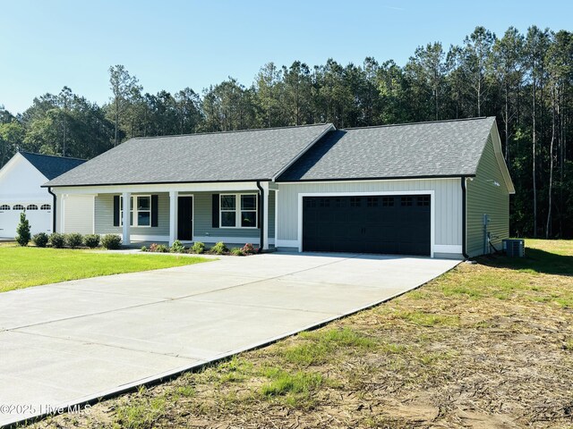 ranch-style home featuring a garage, a front lawn, concrete driveway, roof with shingles, and cooling unit