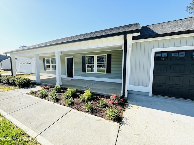 view of front of home featuring covered porch, roof with shingles, and an attached garage