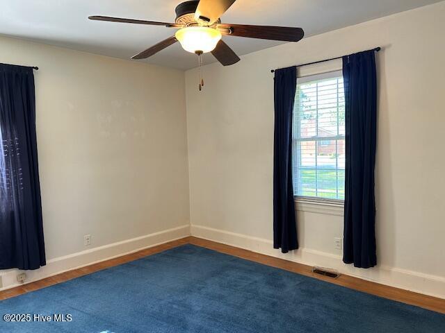 8019 W Tarboro Rd, Rocky Mount, NC 27803 - spare room featuring a ceiling fan, plenty of natural light, wood finished floors, and baseboards