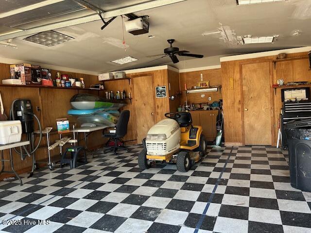 8019 W Tarboro Rd, Rocky Mount, NC 27803 - garage with a garage door opener, wooden walls, and ceiling fan