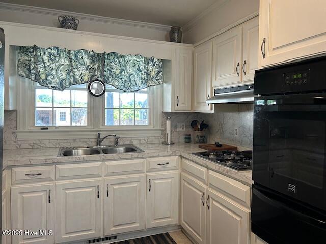 8019 W Tarboro Rd, Rocky Mount, NC 27803 - kitchen with under cabinet range hood, a warming drawer, black oven, a sink, and white cabinets