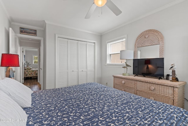 bedroom with ornamental molding, a closet, ceiling fan, and wood finished floors