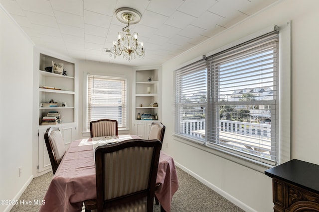 317 Sand Piper Ln, Holden Beach, NC 28462 - dining area featuring built in features, a chandelier, carpet, and baseboards