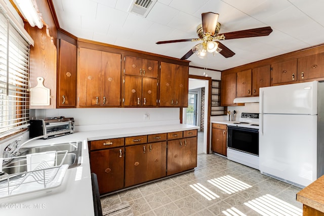317 Sand Piper Ln, Holden Beach, NC 28462 - kitchen with electric stove, freestanding refrigerator, under cabinet range hood, ceiling fan, and light countertops