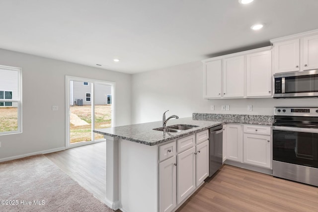 1571 Gate Hill Rd SE, Bolivia, NC 28422 - kitchen with appliances with stainless steel finishes, a sink, white cabinets, a peninsula, and light stone counters