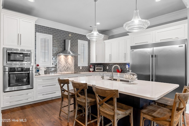 212 Cornubia Dr, Castle Hayne, NC 28429 - kitchen with built in appliances, wall chimney exhaust hood, ornamental molding, light countertops, and a kitchen breakfast bar