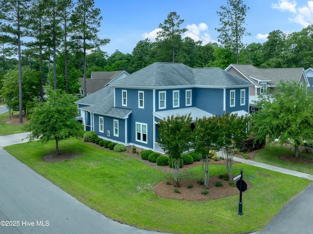 212 Cornubia Dr, Castle Hayne, NC 28429 - view of front facade featuring roof with shingles, a front lawn, and view of scattered trees