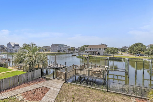 dock area featuring fence, a water view, a residential view, and boat lift