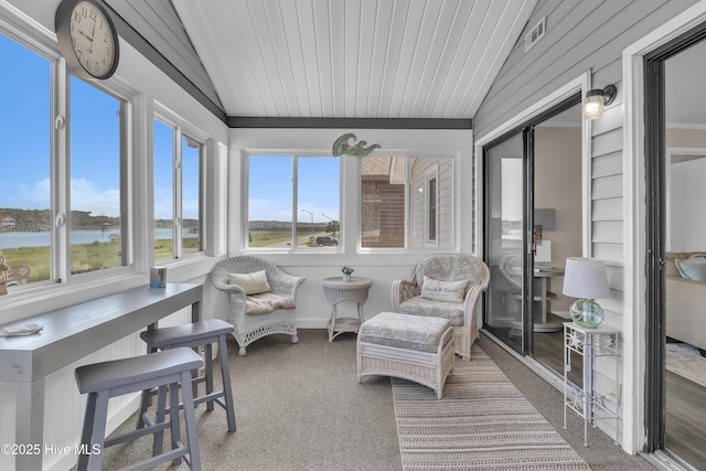 sunroom featuring carpet flooring and a water view