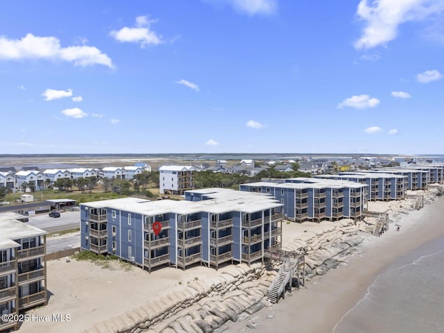 drone / aerial view of a nearby body of water and apartment complex / building