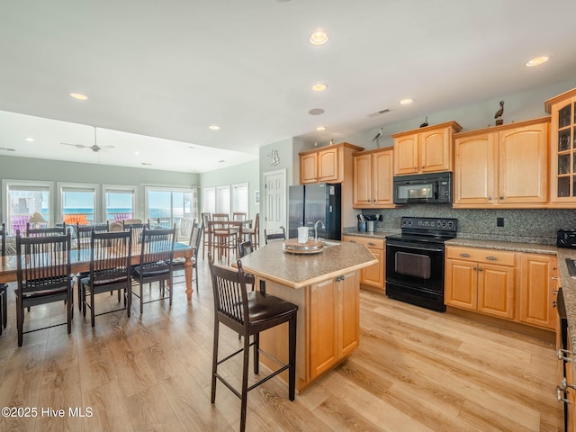 4388 Island Dr, North Topsail Beach, NC 28460 - kitchen with black appliances, plenty of natural light, glass insert cabinets, a sink, and recessed lighting