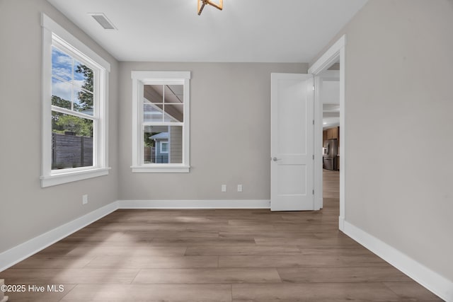 unfurnished room with baseboards and wood finished floors