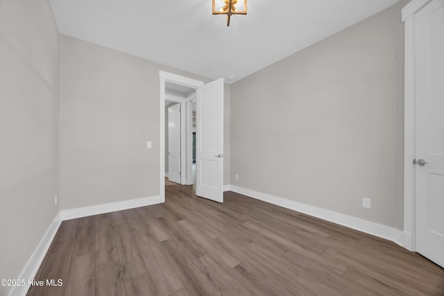 unfurnished room featuring wood finished floors and baseboards