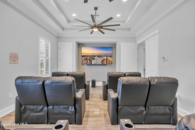 home theater featuring ceiling fan, recessed lighting, light wood-style floors, baseboards, and a raised ceiling