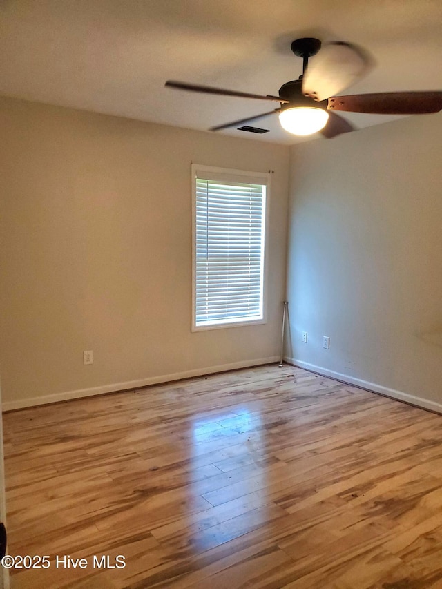 spare room with a ceiling fan, wood finished floors, and baseboards