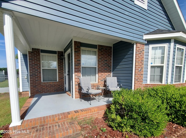 entrance to property with brick siding and covered porch