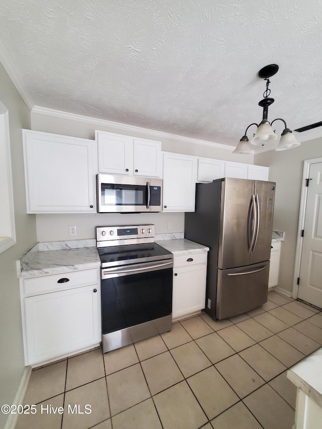 kitchen with appliances with stainless steel finishes, white cabinetry, ornamental molding, hanging light fixtures, and light tile patterned floors