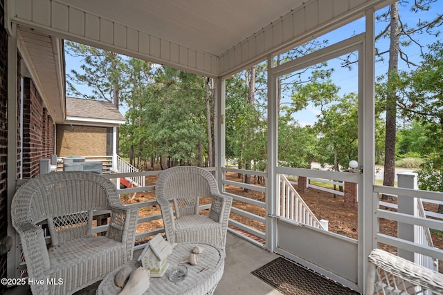 sunroom / solarium featuring view of scattered trees