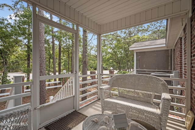 sunroom / solarium featuring view of scattered trees