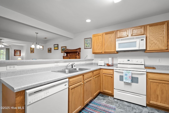 kitchen featuring white appliances, a sink, a peninsula, light countertops, and a ceiling fan