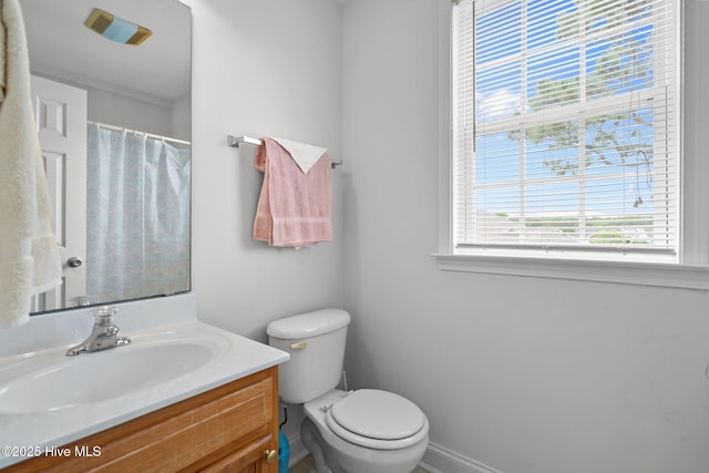 bathroom with vanity, toilet, baseboards, and curtained shower