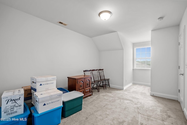 living area with carpet, baseboards, and vaulted ceiling