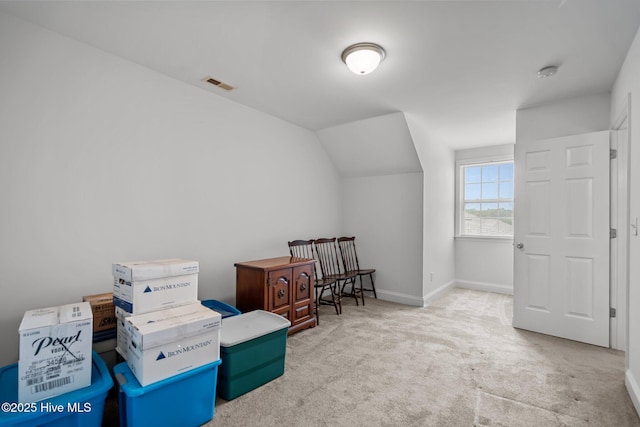 sitting room featuring carpet, vaulted ceiling, and baseboards