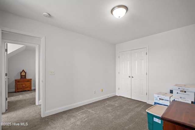 unfurnished bedroom featuring carpet, a closet, and baseboards