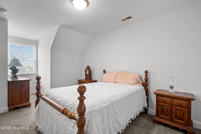 carpeted bedroom with baseboards and lofted ceiling