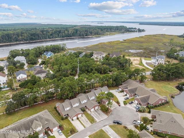 aerial overview of property's location with a heavily wooded area, a nearby body of water, and nearby suburban area