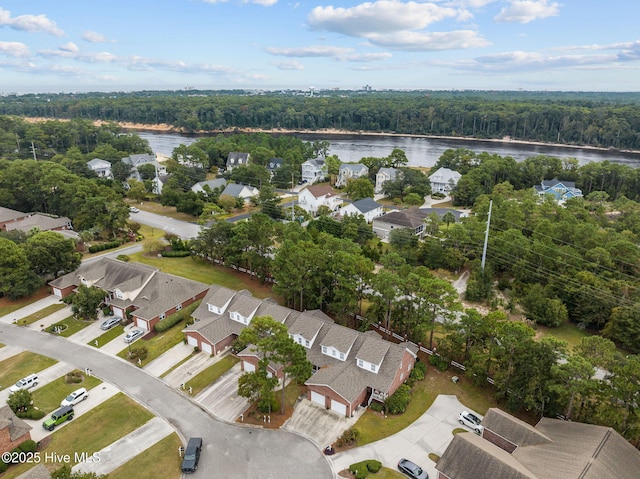 aerial overview of property's location featuring a nearby body of water, a forest, and nearby suburban area