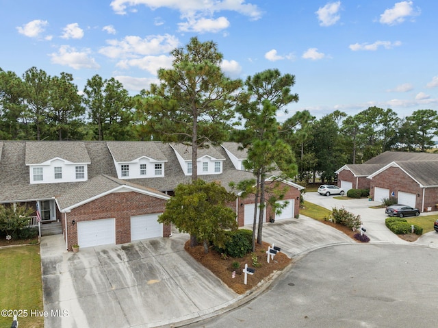 view of front facade featuring brick siding, concrete driveway, a residential view, and a shingled roof