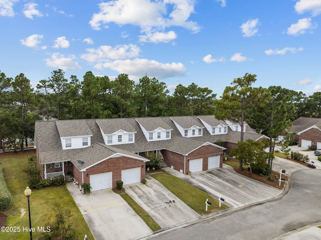 view of front of property with brick siding, concrete driveway, and a front yard