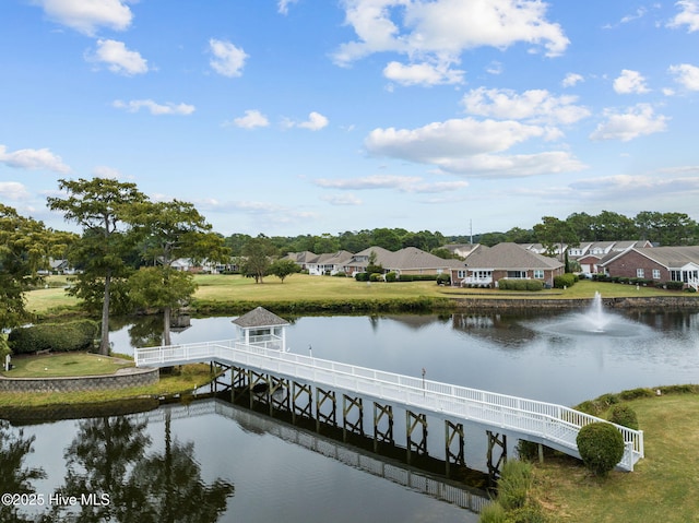 dock featuring a water view, a residential view, and a lawn