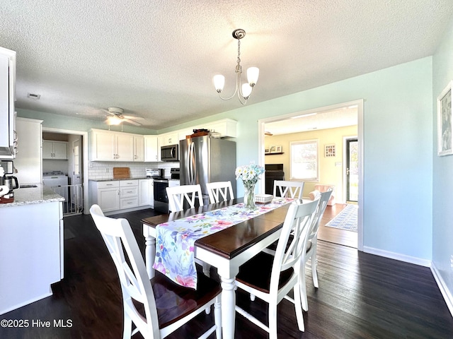 207 Rhonda Rd, Elizabeth City, NC 27909 - dining room featuring washing machine and dryer, dark wood finished floors, a textured ceiling, a chandelier, and baseboards
