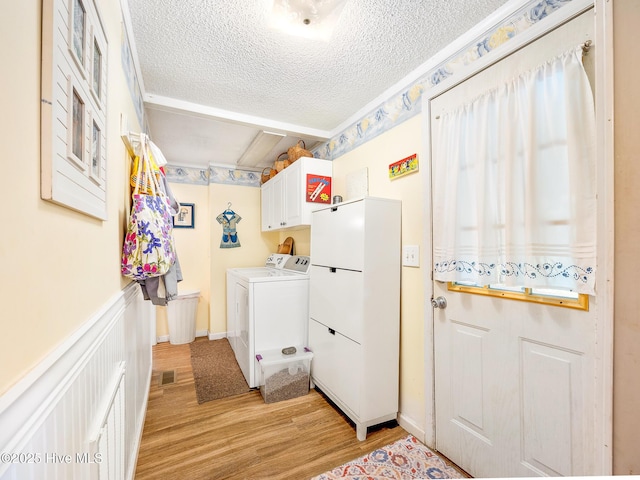 366 Ampersand Rd, Aberdeen, NC 28315 - laundry room with a textured ceiling, cabinet space, washer and clothes dryer, light wood-style flooring, and wainscoting