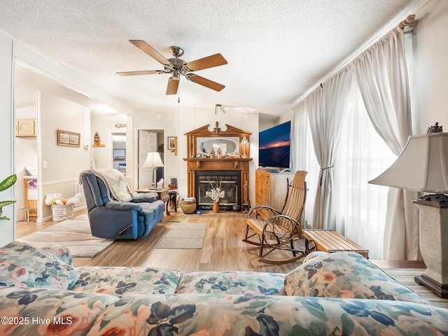 366 Ampersand Rd, Aberdeen, NC 28315 - living area featuring a glass covered fireplace, wood finished floors, a ceiling fan, and a textured ceiling