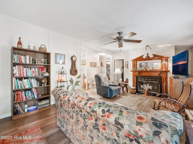 366 Ampersand Rd, Aberdeen, NC 28315 - living area featuring a textured ceiling, a ceiling fan, wood finished floors, and a fireplace