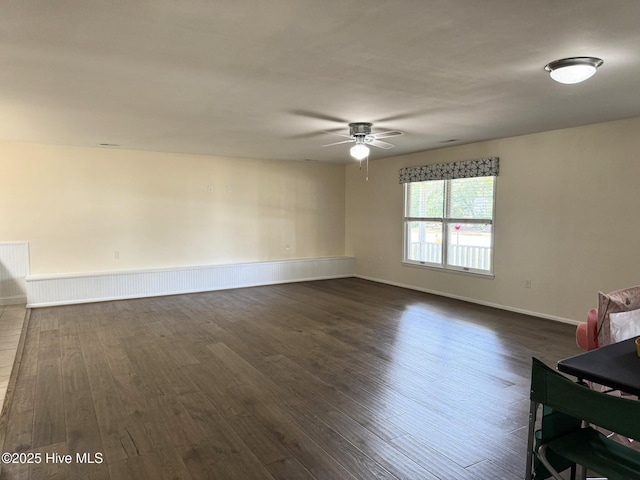 3306 E Oak Island Dr, Oak Island, NC 28465 - unfurnished living room with dark wood-style flooring, a ceiling fan, and baseboards
