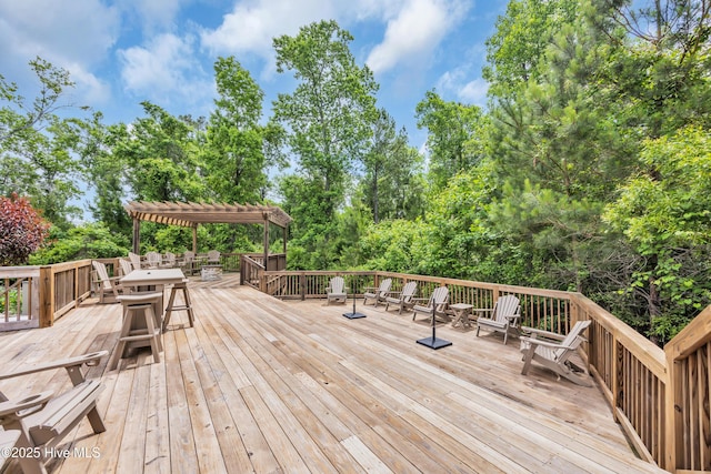 1961 Indigo Cove Way, Calabash, NC 28467 - deck with a pergola, outdoor dining space, and view of wooded area