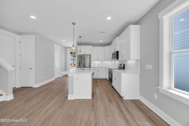 1961 Indigo Cove Way, Calabash, NC 28467 - kitchen with stainless steel appliances, light countertops, white cabinetry, hanging light fixtures, and recessed lighting