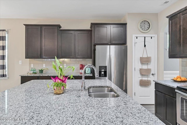 145 Cabin Branch Dr, Carthage, NC 28327 - kitchen featuring stainless steel appliances, a sink, dark brown cabinetry, and light stone counters